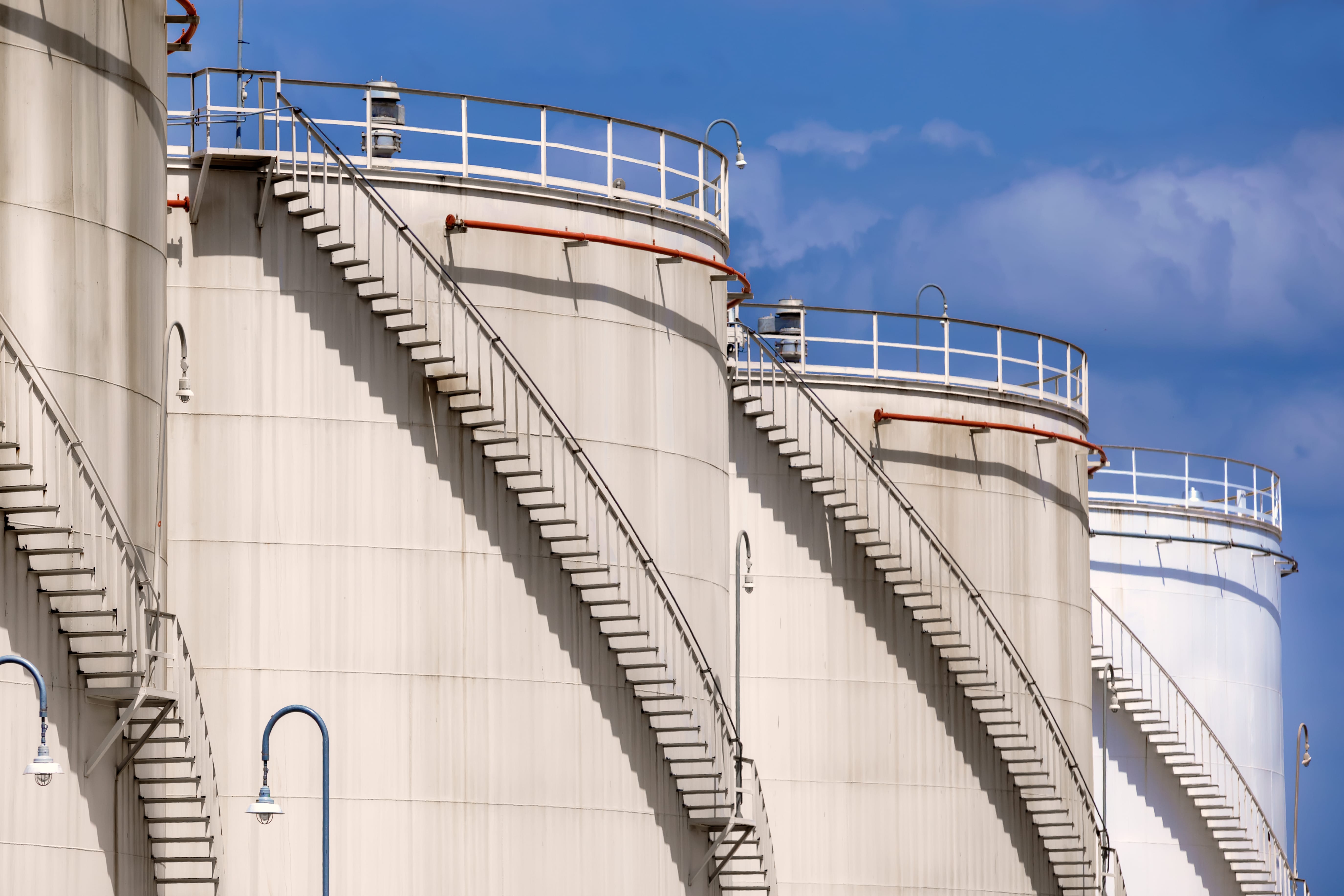 Industrial storage tanks with exterior staircases at a facility supporting environmental compliance and regulatory operations.