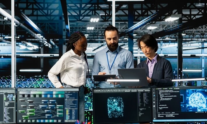 Team reviewing data visualization screens in server facility